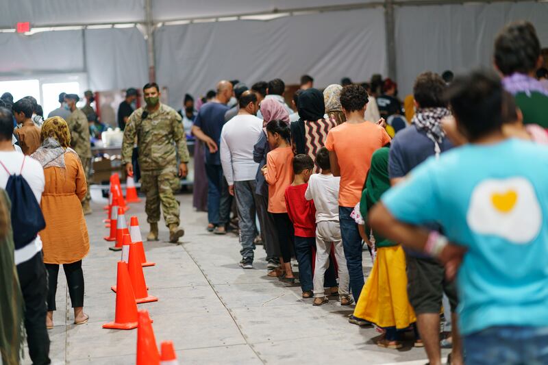 Afghan refugees line up for food at a U.S. military base.