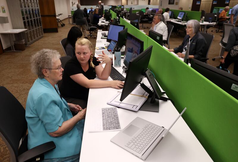 Sister Barbara Moon, left, gets help translating Swedish documents from Savannah Larson, Nordic research specialist, at the Family History Library.