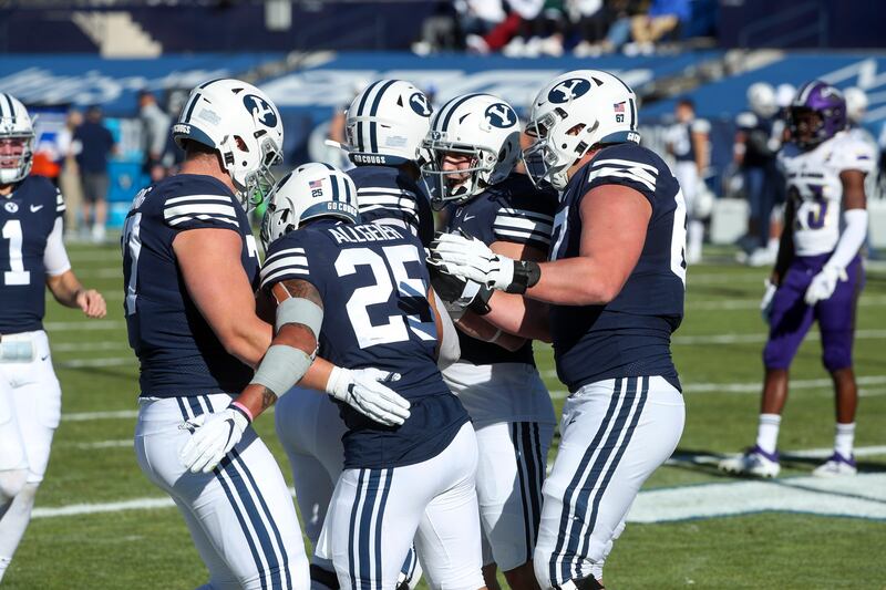 Brigham Young University football’s offensive line congratulates running back Tyler Allgeier after he scores a touchdown against North Alabama in Provo during the 2020 season.
