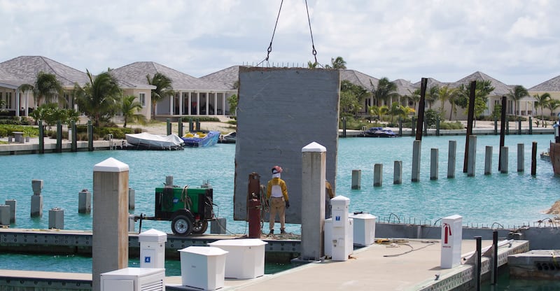 A construction worker stands on the expanded dock for Resorts World Bimini resort.