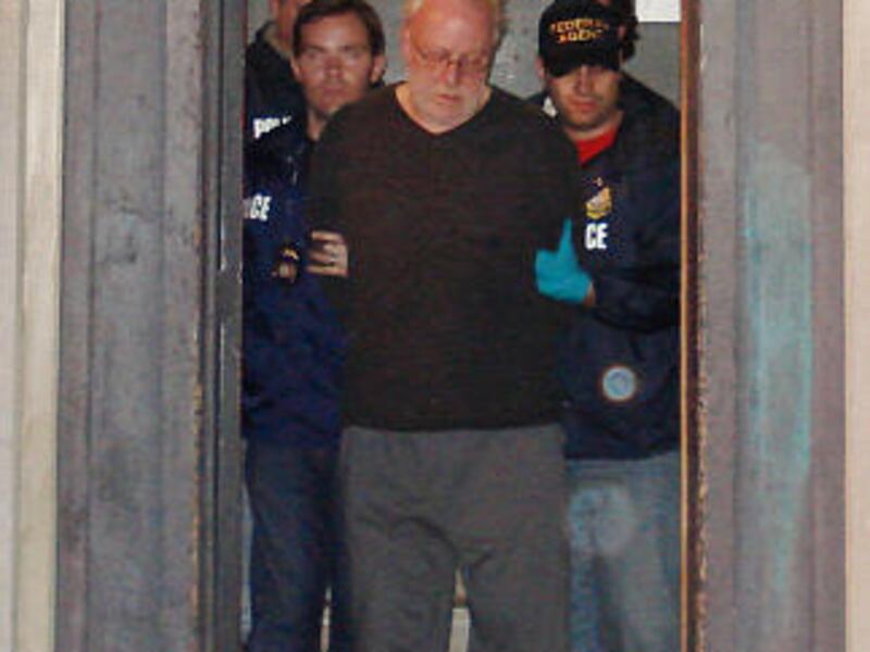 Customs agents escort Wayne Nelson Corliss from his New Jersey apartment building after his arrest on Thursday.