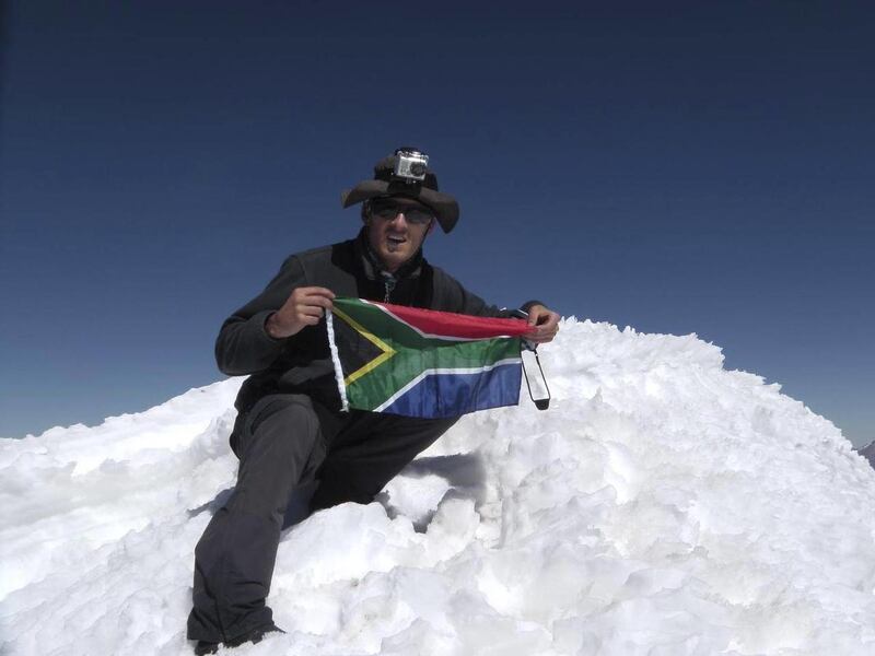 In this undated photo released on Monday Aug. 27, 2012 by the family of South African adventurer David du Plessis, 24, du Plessis holds up the flg of South Africa as he reaches the summit of Mount Mismi located in the Andes mountain range of Peru. David d