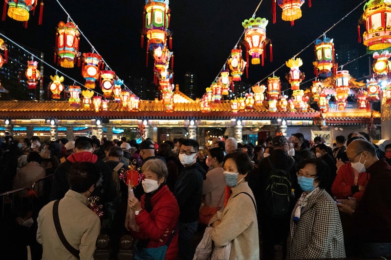 Worshippers wearing face masks line up to enter the Wong Tai Sin Temple to burn their first joss sticks in Hong Kong, Saturday, Jan. 21, 2023.