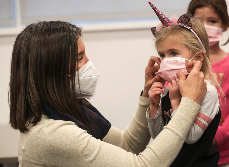 Salt Lake City Mayor Erin Mendenhall helps 3-year-old Della Barker Asman with her mask.