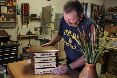 Jim Christensen shows off a small chest he designed and built.
