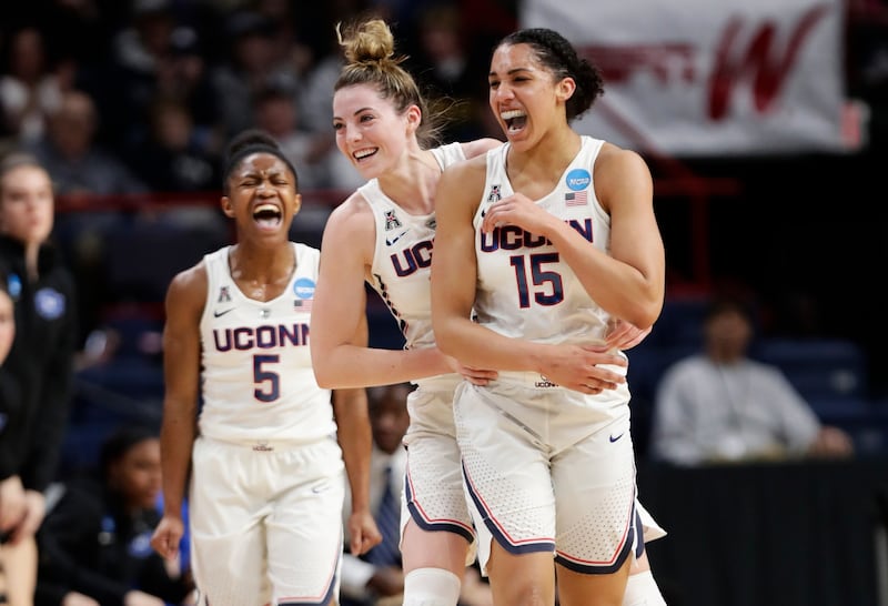 Connecticut's Crystal Dangerfield (5) and Katie Lou Samuelson (33) celebrate a 3-point basket by Gabby Williams (15) during the first half in a regional semifinal against Duke at the NCAA women's college basketball tournament Saturday, March 24, 2018, in
