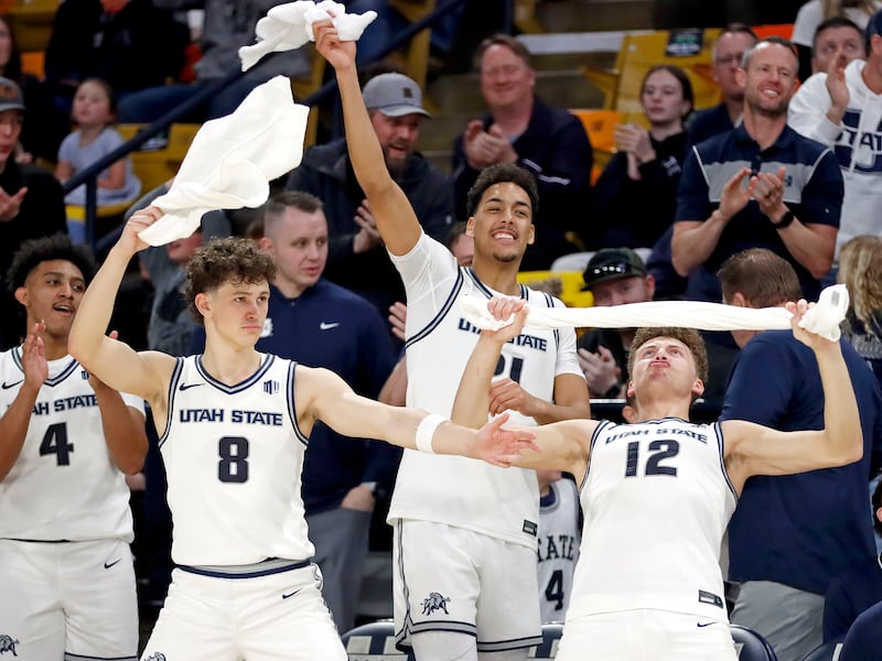 Utah State basketball players Ian Martinez, left, Drake Allen, Aubin Gateretse and Mason Falslev celebrate on the bench near the end of the Aggies' 87-47 win over Air Force on March 8, at the Spectrum in Logan.