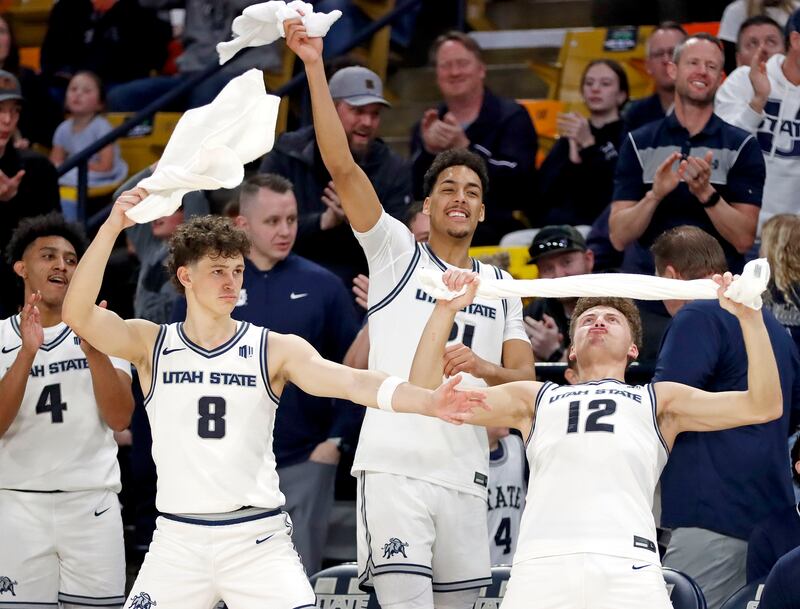 Utah State basketball players Ian Martinez, left, Drake Allen, Aubin Gateretse and Mason Falslev celebrate on the bench near the end of the Aggies' 87-47 win over Air Force on March 8, at the Spectrum in Logan.