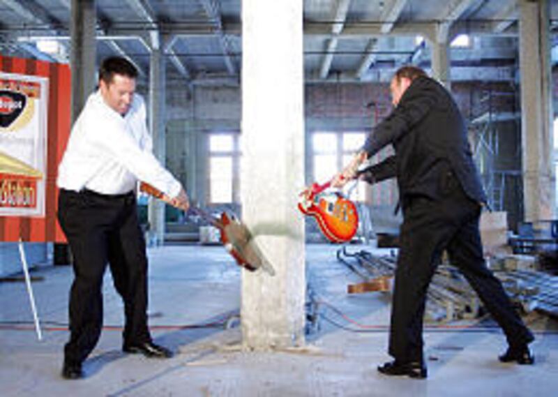 David Cumming and Jim McNeil smash guitars inside the old depot Thursday to help launch club project.