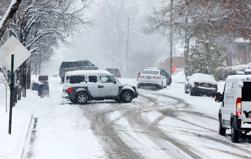 Cars struggle to negotiate streets in the avenues as snow falls in Salt Lake City on Tuesday, Dec. 13, 2022.