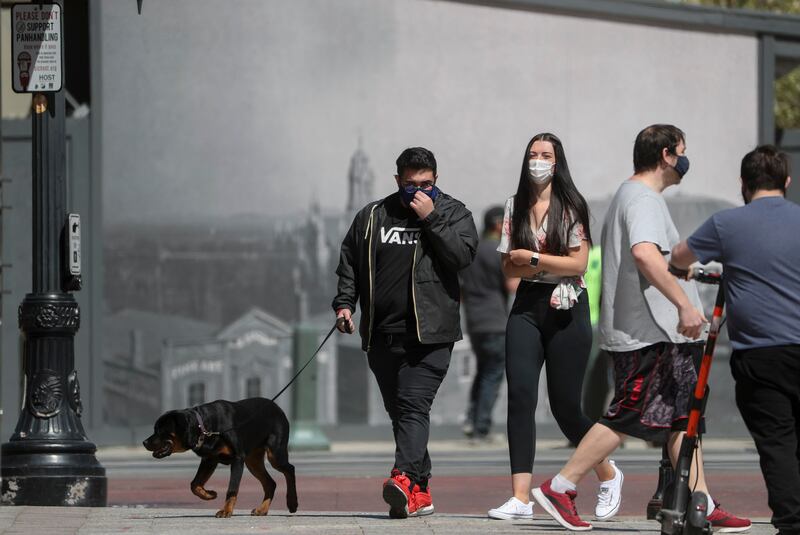 Pedestrians wear masks as they walk on Main Street in Salt Lake City on Friday, April 9, 2021.