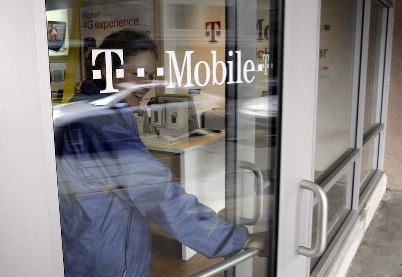 A customer walks out of a T-Mobile store in Palo Alto, Calif., Friday, Feb. 25, 2011.