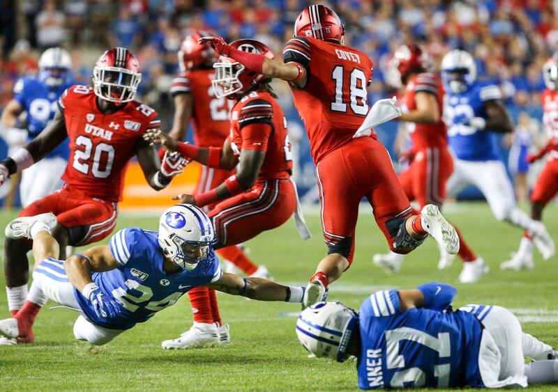 Utah wide receiver Britain Covey (18) is tripped up by BYU defensive back Austin Kafentzis (24).