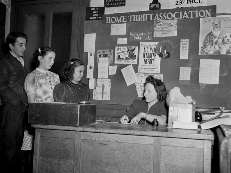 At the Home Thrift Association in Yorkville, a German neighborhood of Manhattan, New York, Dorothy Lamparter fills out the applications of youngsters seeking to join the association, Jan. 22, 1942. The organization instructs children in good citizenship.