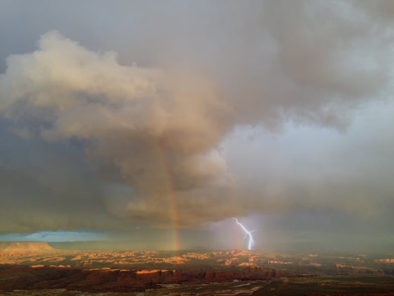 FILE - Lightning and a rainbow over the Canyonlands National Park.