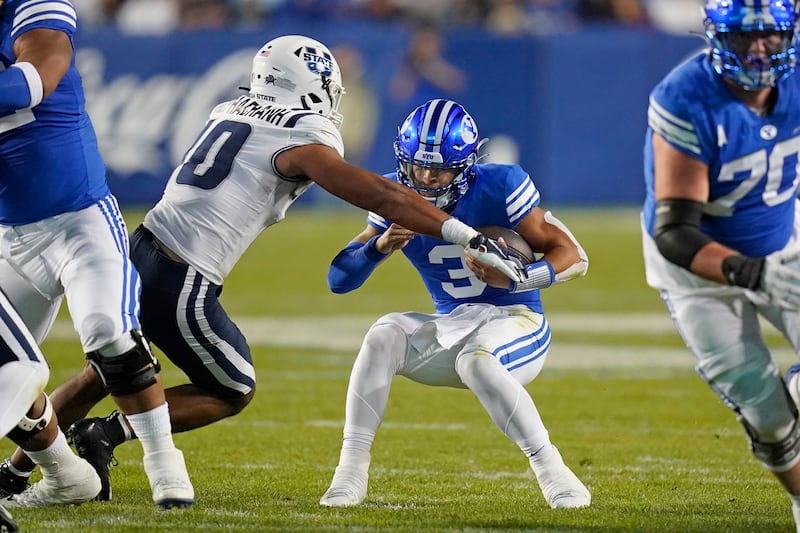 BYU quarterback Jaren Hallis sacked by Utah State linebacker AJ Vongphachanh during game in Provo, Utah.