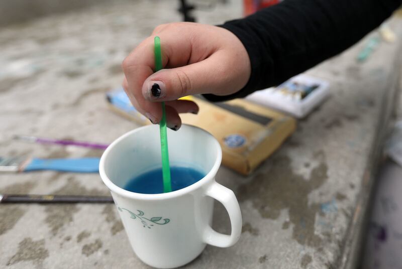 Christine, who struggles with anxiety, paints outside of her home in Murray on Friday, May 18, 2018. Painting helps her express her emotions.