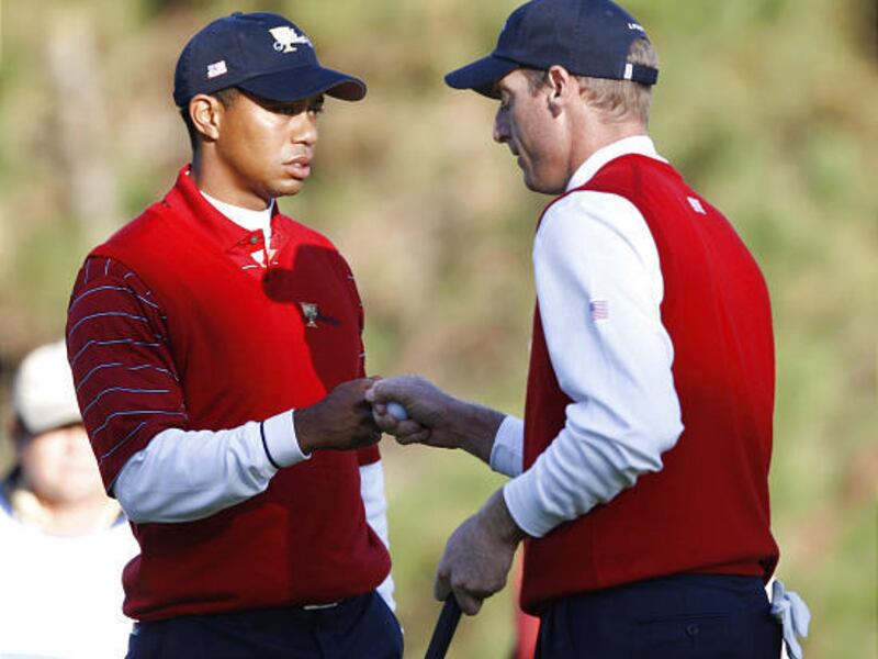 Tiger Woods, left and Jim Furyk celebrate after Furyk putted on the fifth hole during play at the Presidents Cup golf tournament Saturday in Montreal.