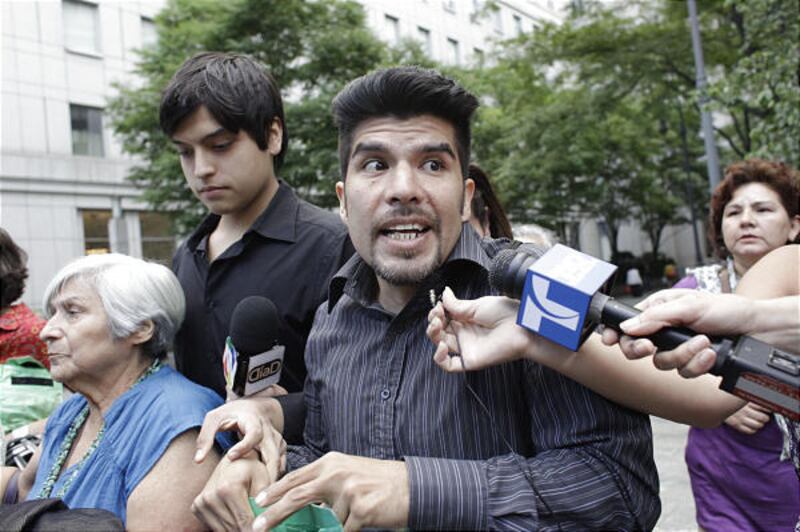 Waldo Mariscal, 38, second from left, and Juan Lazaro Jr., 17, both sons of Vicky Pelaez, are surrounded by reporters as they leave Manhattan Federal Court Thursday.