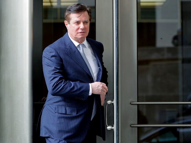 FILE - In this Feb. 14, 2018 file photo, Paul Manafort, President Donald Trump's former campaign chairman, leaves the federal courthouse in Washington. Manafort says in a statement that a Guardian report saying he met with Assange at the Ecuadorian embass