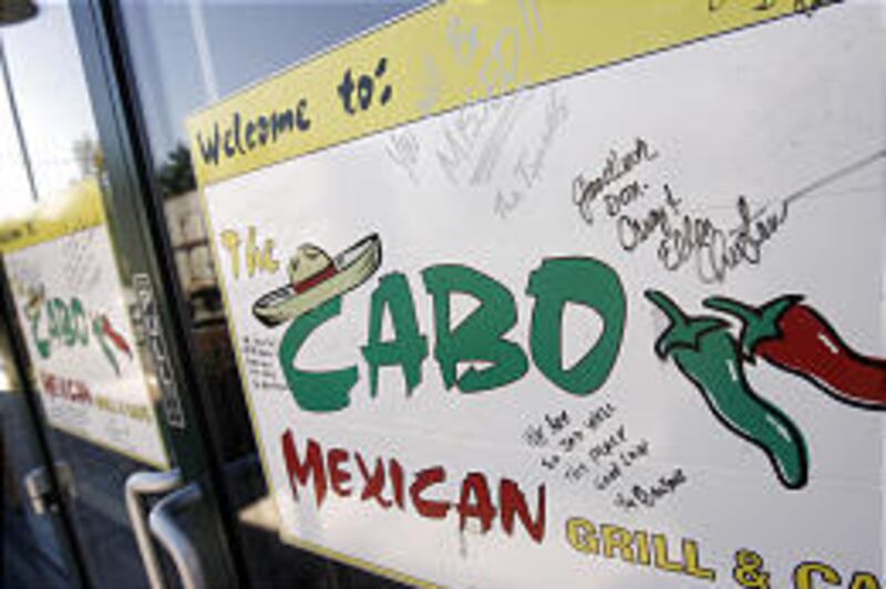 A sign on the door of Cabo Mexican Grill and Cafe wishes founder Don Hainsworth well as he switches roles from owner to front manager after selling the restaurant to loyal customer Cameron Tea.