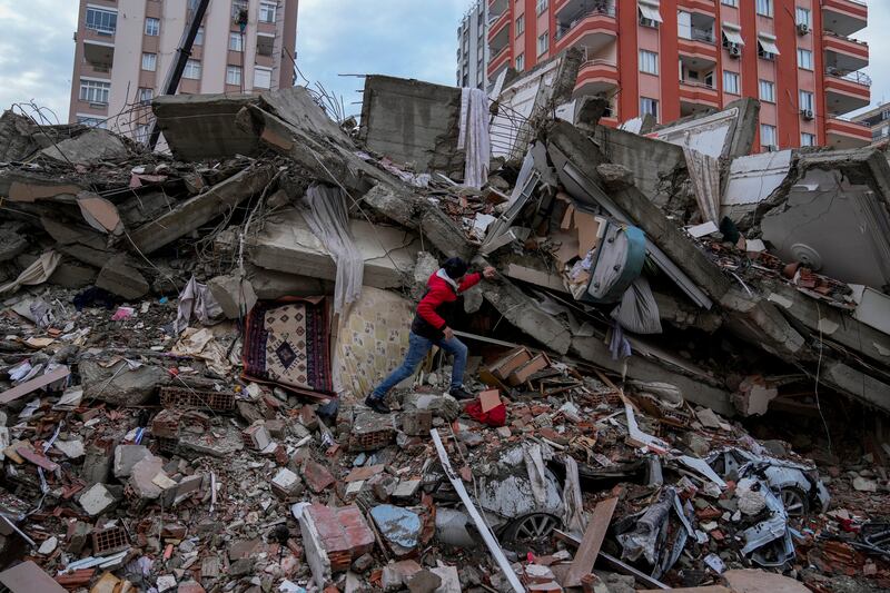 A man searches a destroyed building in Adana, Turkey, Monday, Feb. 6, 2023. A powerful quake killed more than 3,800 people.