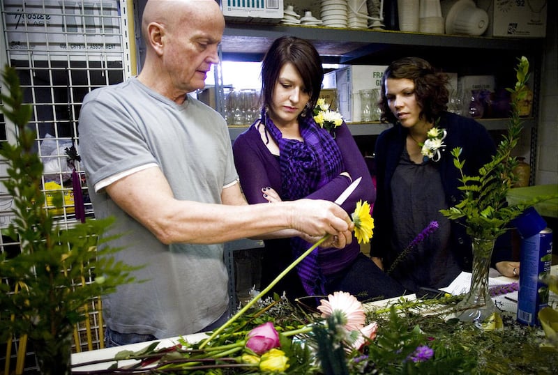 Chad Wright, left, shows Teddy Parker and Brittany Barney how to prepare a flower for a vase during their first class.