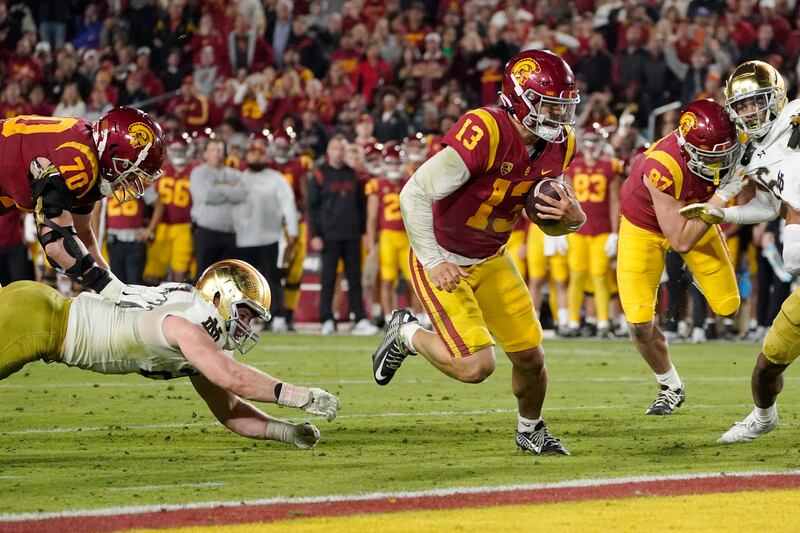 Southern California quarterback Caleb Williams (wearing red) runs in for touchdown during the first half of an NCAA college football game against Notre Dame Saturday, Nov. 26, 2022, in Los Angeles.