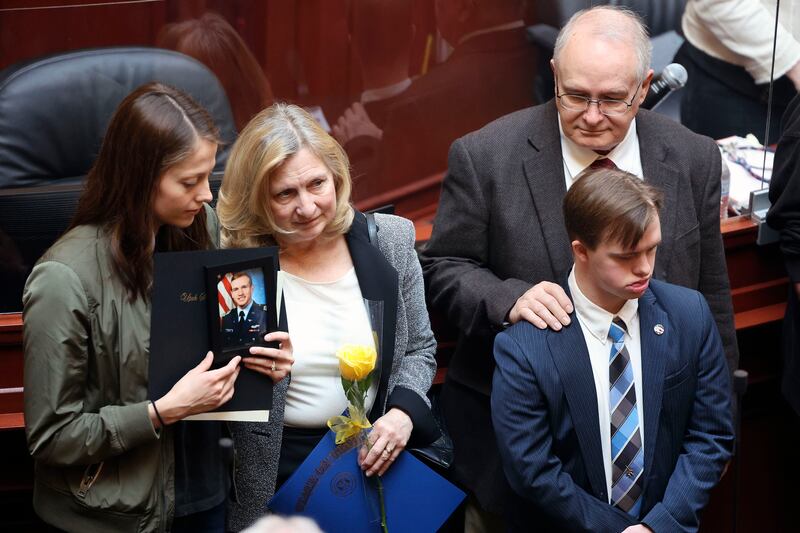 Hannah Allen, left, holds a photo of her late husband, 1st Lt. Kage Allen, as she and his parents, Deborah and Mark Allen, and his brother, Stephen Allen, are honored with other families of fallen Utah military members in the House chamber at the Capitol in Salt Lake City.