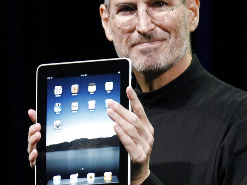 Steve Jobs holds the iPad during a product announcement event.