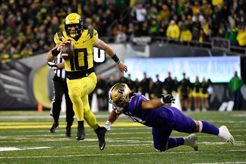 Oregon quarterback Bo Nix eludes a tackle during game Saturday, Nov. 12, 2022, in Eugene, Ore.