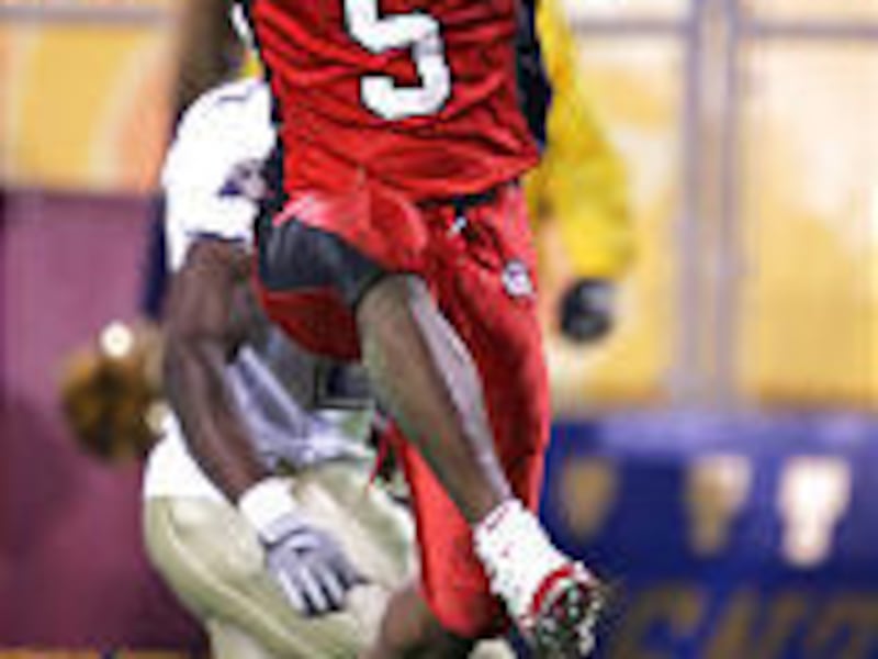 The University of Utah's Paris Warren leaps over a teammate and into the end zone, scoring his first touchdown during the Fiesta Bowl.