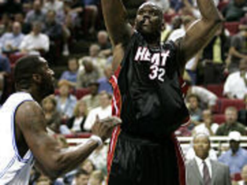 Miami's Shaquille O'Neal looks to score over Orlando's Tony Battie. O'Neal finished with 24 points but it wasn't enough.
