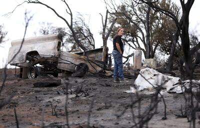 Linda Adams looks at the damage after the Dollar Ridge Fire in Fruitland on Wednesday, July 11, 2018. The fire destroyed her home, shed and camper.