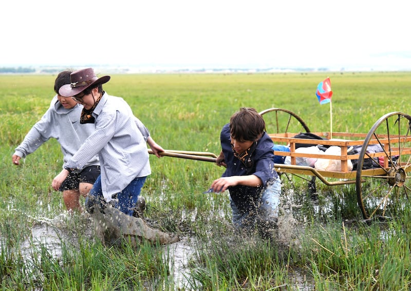 Latter-day Saint youth and leaders participate in trek, pulling a handcart through mud during the June 13 and 14, 2025, trek near Ulaanbatar, Mongolia.