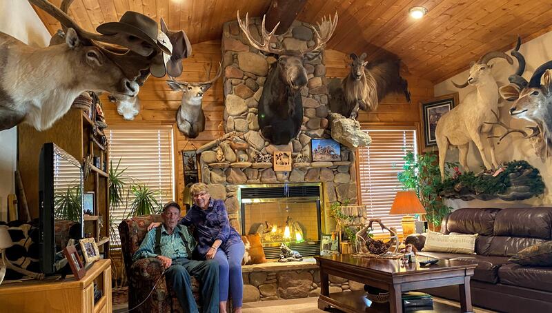 Jerry and Carolyn Christensen sit in Jerry’s big game trophy room at their home in Heber City.