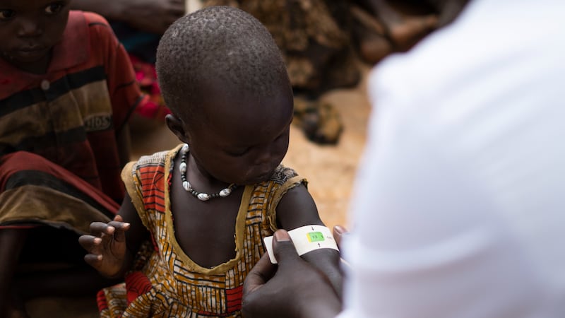 A UNICEF worker uses an arm band to detect malnutrition in a child in northeastern Uganda, in March 2023.