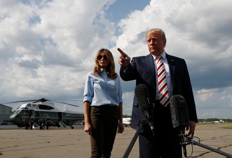 President Donald Trump, with first lady Melania Trump, speaks to the media before boarding Air Force One in Morristown, N.J., Sunday, Aug. 4, 2019. (AP Photo/Jacquelyn Martin)