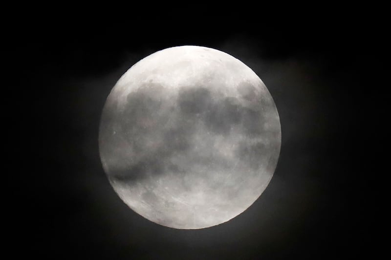 A nearly full moon shines over Yankee Stadium during a baseball game between the New York Yankees and the Philadelphia Phillies