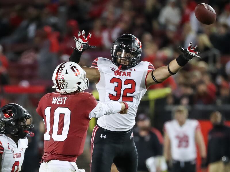 Stanford Cardinal quarterback Jack West (10) passes under pressure from Utah Utes linebacker Karene Reid (wearing white)