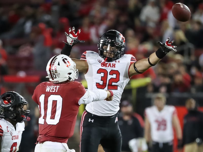 Stanford Cardinal quarterback Jack West (10) passes under pressure from Utah Utes linebacker Karene Reid (wearing white)