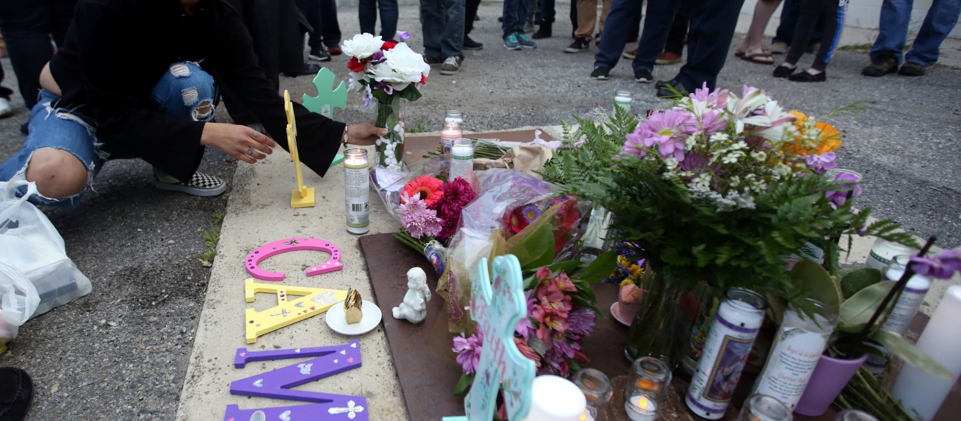 Paige Stuart leaves flowers during a vigil for her mother, Cami Shepherd, in West Valley City on Monday, April 16, 2018.