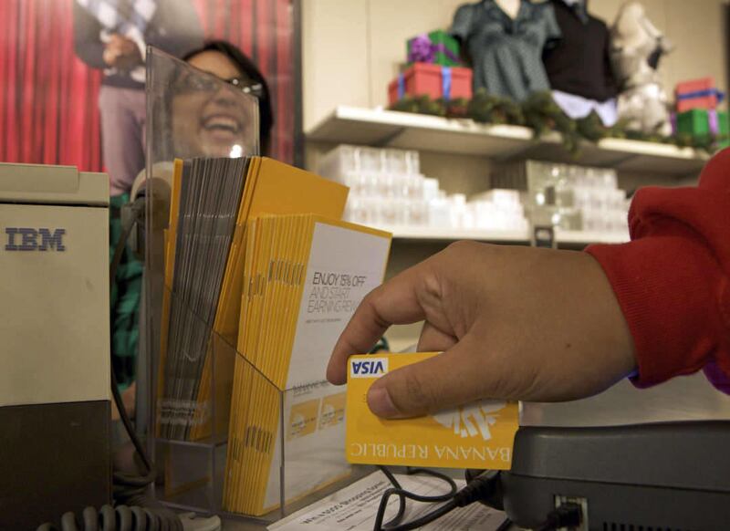 In this photo made Friday, Dec. 11, 2009, a customer uses his Banana Republic-issued VISA credit card to pay for a purchase at a Banana Republic store in Commerce, Calif. (AP Photo/Damian Dovarganes)