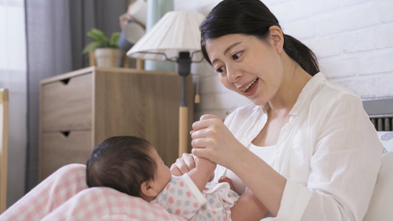 A mother plays with her infant.