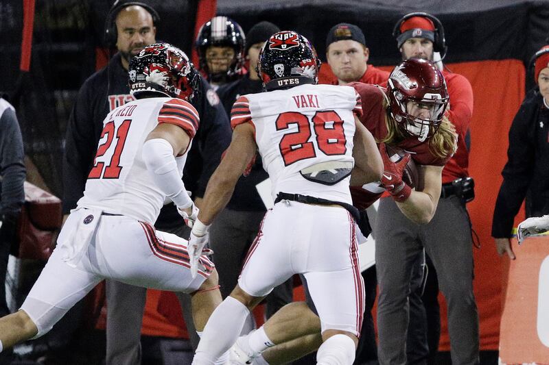 Utah linebacker Karene Reid, left, and safety Sione Vaki pursue Washington State’s Billy Riviere III in Pullman, Wash.