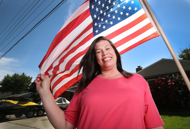 Lori Lloyd poses with an American flag at her home in Midvale, Utah, on Saturday, June 15, 2019. Lloyd is a mother of three and a former meth addict who was incarcerated from 2007-2009.