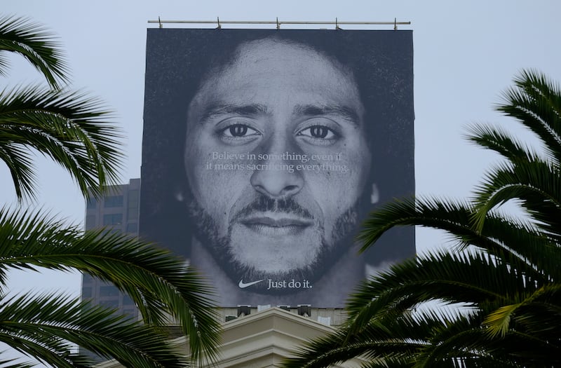 Palm trees frame a large billboard on top of a Nike store that shows former San Francisco 49ers quarterback Colin Kaepernick at Union Square, Wednesday, Sept. 5, 2018, in San Francisco. An endorsement deal between Nike and Colin Kaepernick prompted a floo