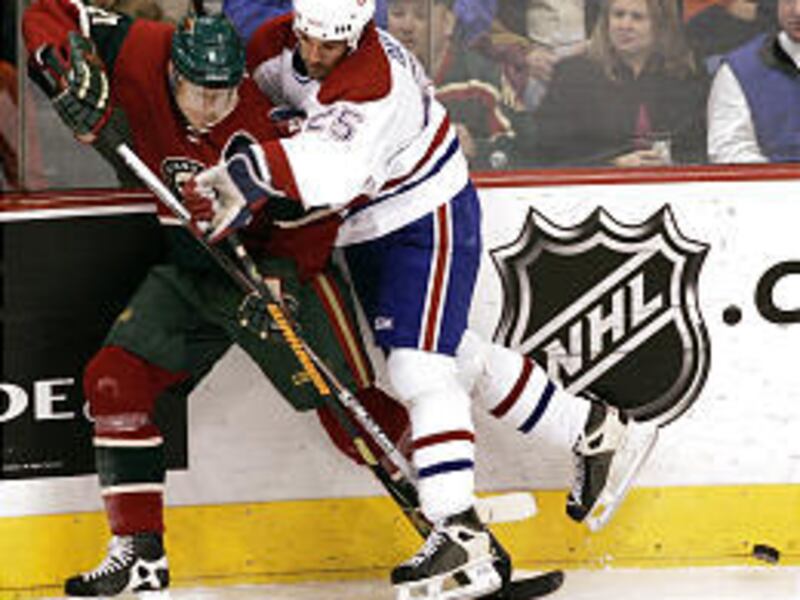 Wild center Mikko Koivu, left, competes for the puck with Montreal's Dandenault.