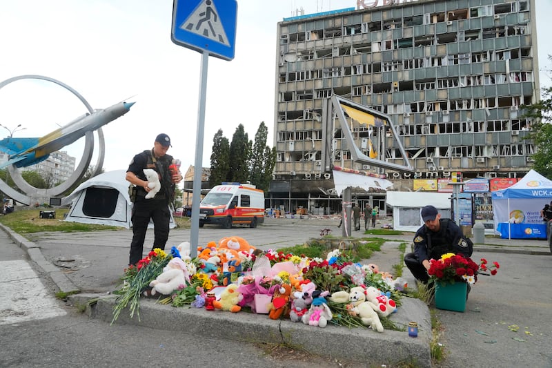 Ukrainian servicemen on Friday, July 15, 2022, lay flowers at the site of a Russian shelling on Thursday in Vinnytsia, Ukraine.