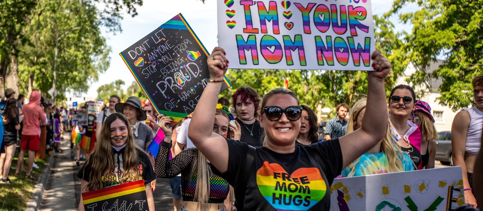 Individuals hold up signs during the Rainbow March along State Street and 900 South headed to Liberty Park in Salt Lake City on Sunday, June 6, 2021.